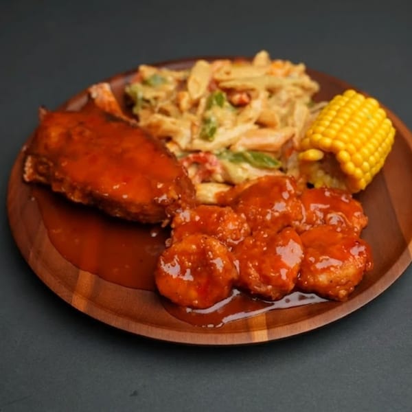 A wooden plate with Jamaican jerk chicken, shrimp, pasta salad, and corn on the cob.